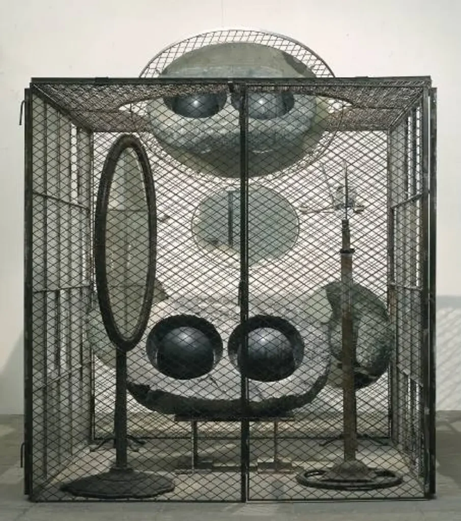 Louise Bourgeois'nın tel örgülerle çevrili, içinde büyük yuvarlak aynalar ve mermer göz heykelleri bulunan, klostrofobik sanat enstalasyonu.